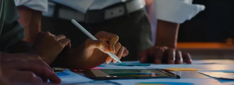 Manos trabajando sobre planos y gráficos