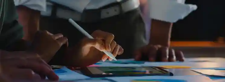 Manos trabajando sobre planos y gráficos